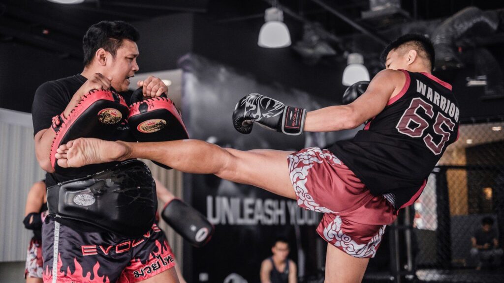 Muay Thai fighter throws a body kick on the kick pads.