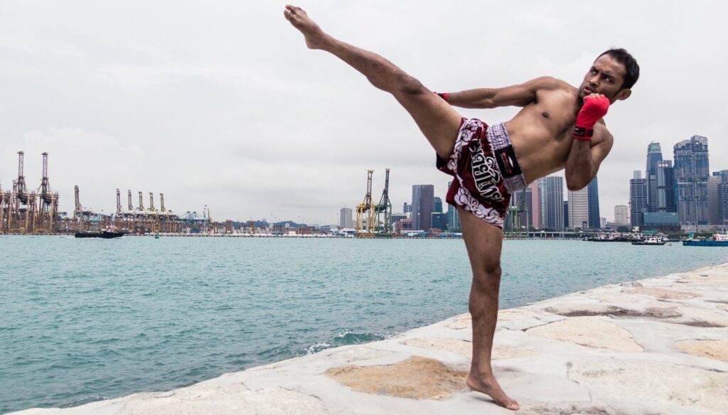 Fighter throws a high kick along a pier